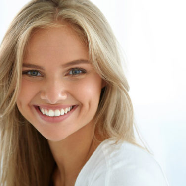 Beauty Woman Portrait. Closeup Of Beautiful Happy Girl With Perfect Smile, White Teeth Smiling At Camera. Attractive Healthy Young Female With Fresh Natural Face Makeup Indoors. High Resolution Image